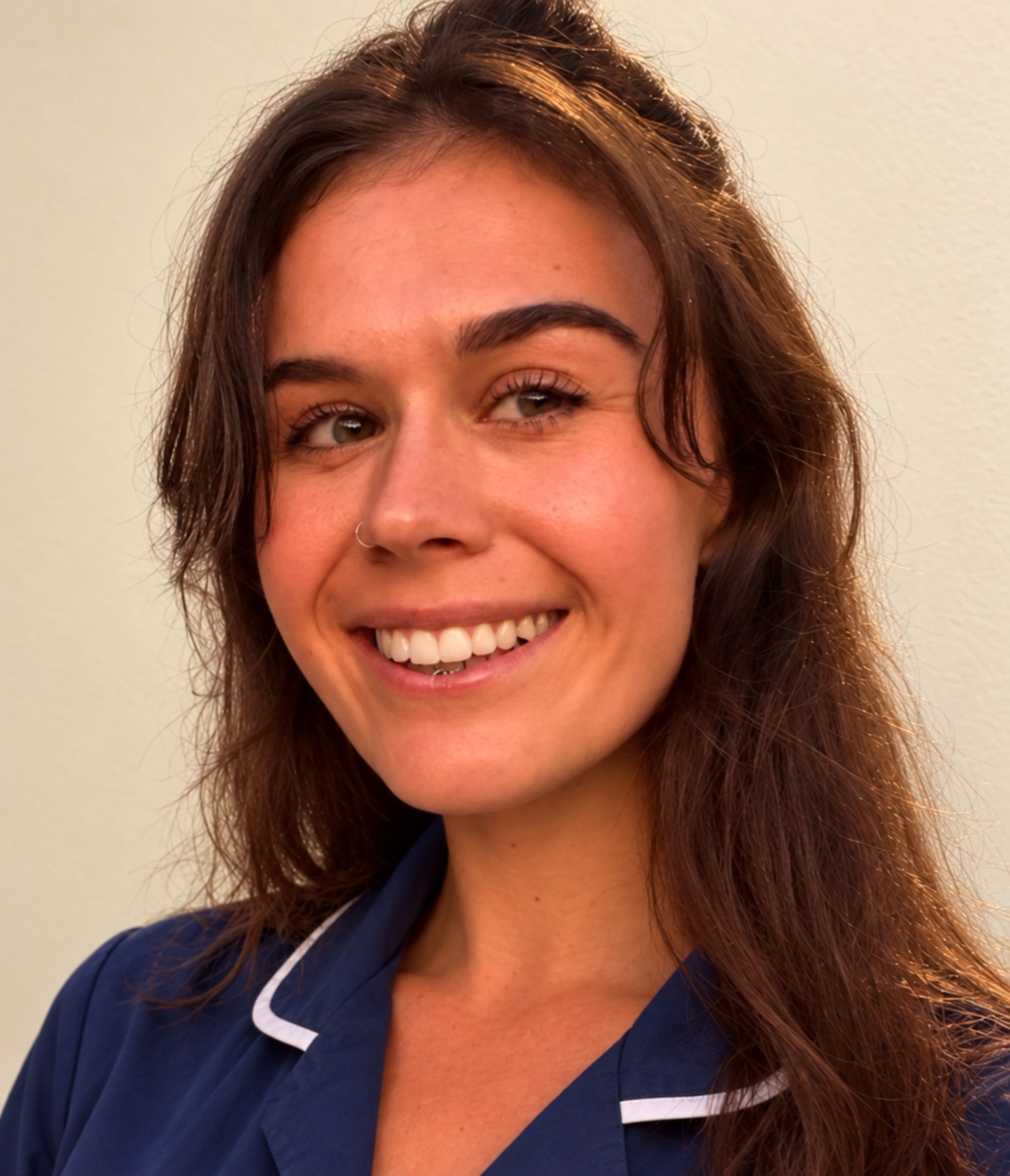 Kayleigh smiling in a navy midwife tunic